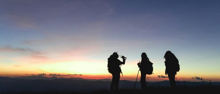 silhouettes of hikers on a ridge