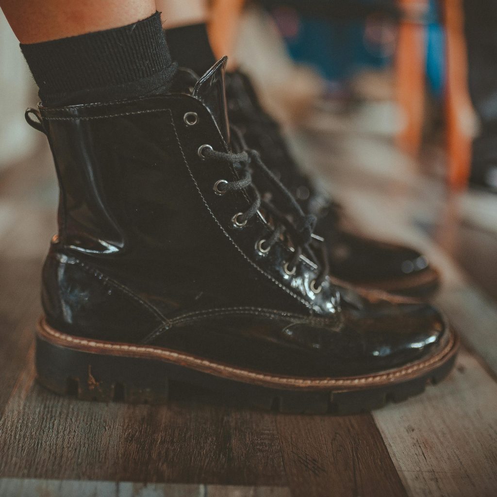 shiny pair of boots on wood floor