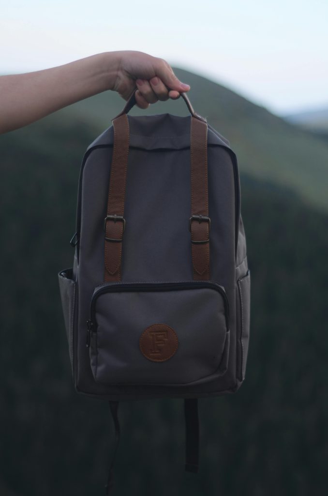 a gray and brown backpack with a logo