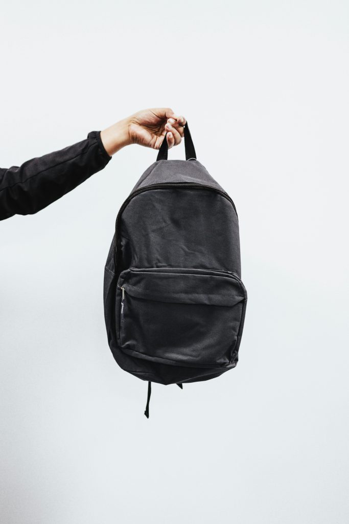 a small backpack hanging off someone's hand