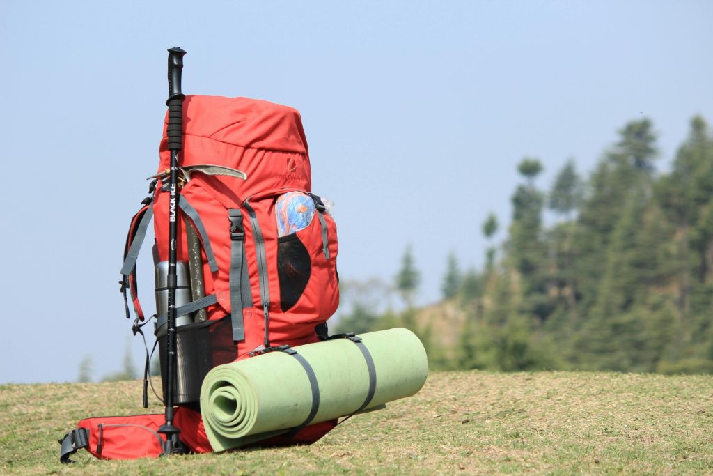a backpack with umbrella and a mat